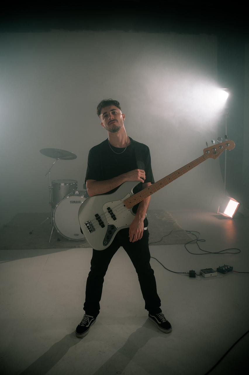 Leandro Juarez holding a bass in a studio